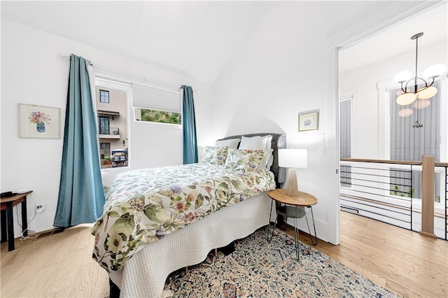 10862 Serenbe Ln, Chattahoochee Hills, GA 30268 - bedroom featuring vaulted ceiling, wood finished floors, and a chandelier