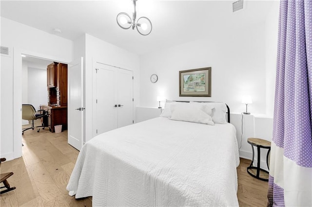 10862 Serenbe Ln, Chattahoochee Hills, GA 30268 - bedroom featuring light wood finished floors, a desk, a closet, and a chandelier