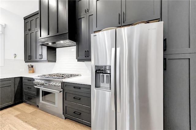 10862 Serenbe Ln, Chattahoochee Hills, GA 30268 - kitchen with stainless steel appliances, ventilation hood, backsplash, light wood-style floors, and light countertops