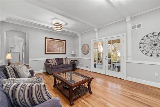 living room featuring french doors, beam ceiling, crown molding, and hardwood / wood-style flooring