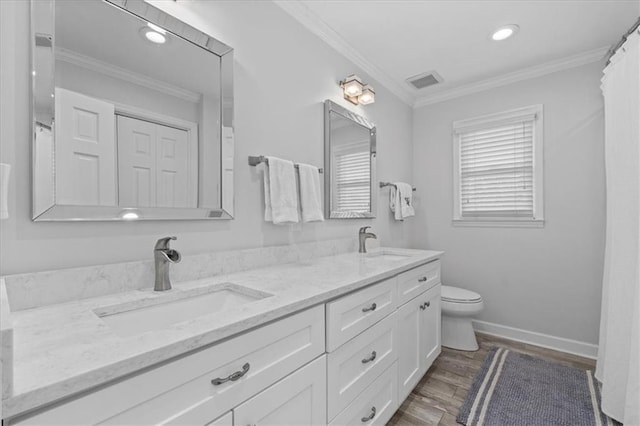 bathroom with hardwood / wood-style flooring, crown molding, vanity, and toilet