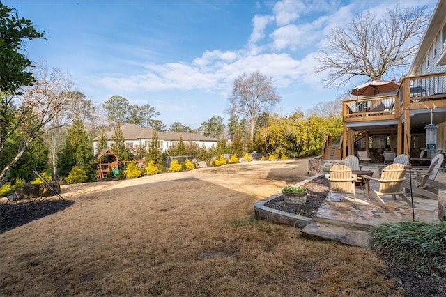 view of yard with a wooden deck, an outdoor fire pit, and a patio area