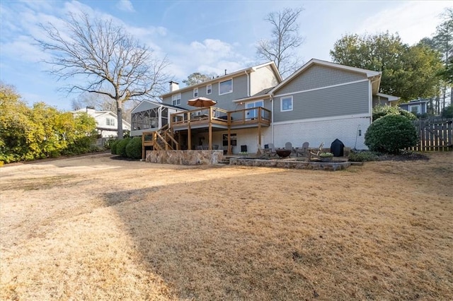 back of house featuring a yard, a sunroom, and a deck