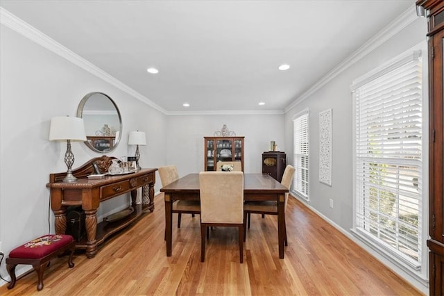 dining space featuring ornamental molding and light hardwood / wood-style flooring