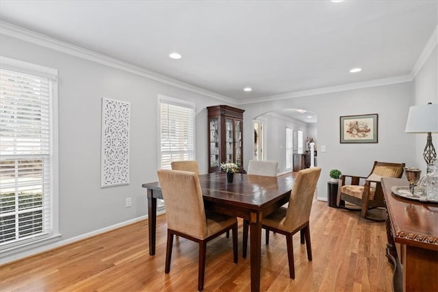 dining room with plenty of natural light, ornamental molding, and light wood-type flooring