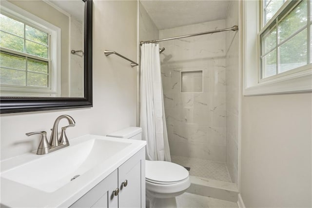 full bathroom with toilet, a tile shower, and vanity