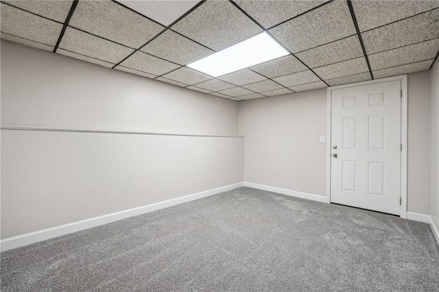 finished basement featuring carpet floors, baseboards, and a drop ceiling