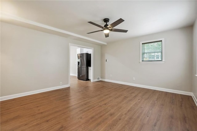 spare room with baseboards, a ceiling fan, and wood finished floors