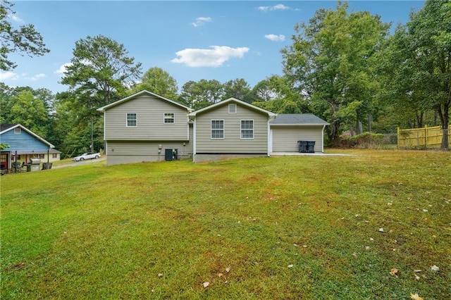 rear view of property featuring a lawn, fence, and cooling unit