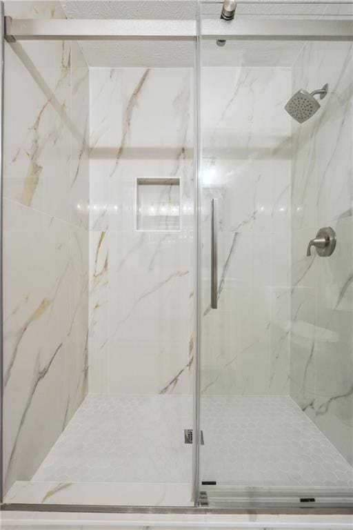 full bathroom with a marble finish shower
