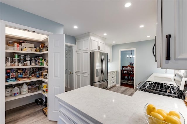 kitchen with white cabinetry, light wood-style floors, recessed lighting, and stainless steel refrigerator with ice dispenser