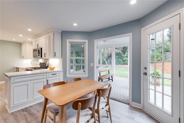 dining room featuring light wood-style flooring, recessed lighting, and baseboards