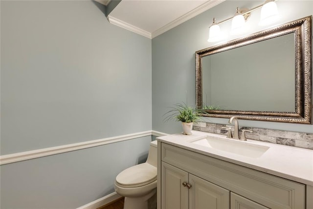 bathroom featuring vanity, toilet, and crown molding