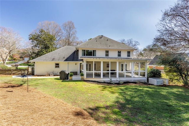 back of house with fence, a yard, and a sunroom