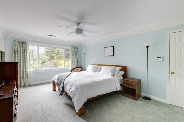 carpeted bedroom featuring visible vents, baseboards, a ceiling fan, and crown molding