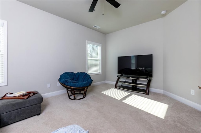 sitting room with ceiling fan and light colored carpet