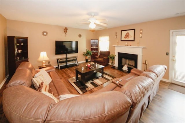 1801 Deer Crossing Cir, Jonesboro, GA 30236 - living room with a ceiling fan, wood finished floors, a fireplace with raised hearth, and baseboards