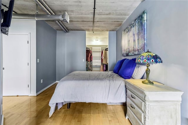 800 Peachtree St NE Unit 2304, Atlanta, GA 30308 - bedroom featuring light wood-style flooring, a walk in closet, and a closet