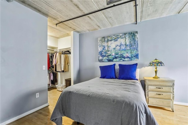 800 Peachtree St NE Unit 2304, Atlanta, GA 30308 - bedroom featuring wood finished floors, baseboards, a walk in closet, and a closet