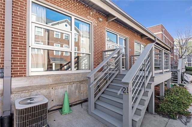 property entrance with central air condition unit and brick siding