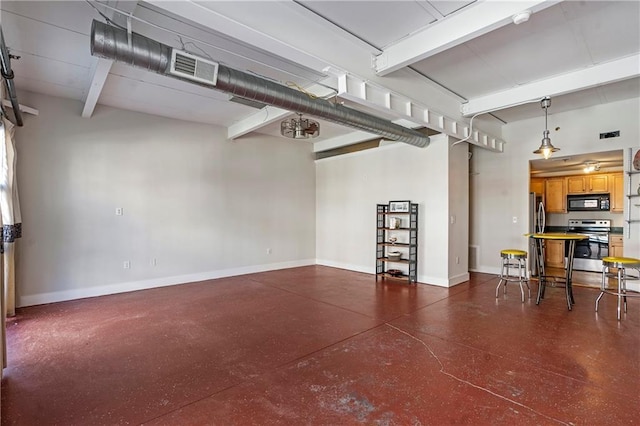 garage with freestanding refrigerator, visible vents, and baseboards