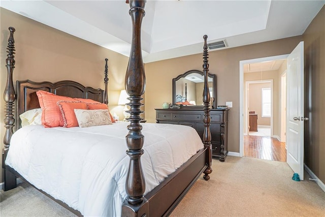 carpeted bedroom with a tray ceiling