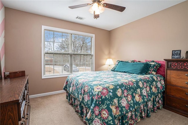 bedroom with multiple windows, light carpet, and ceiling fan