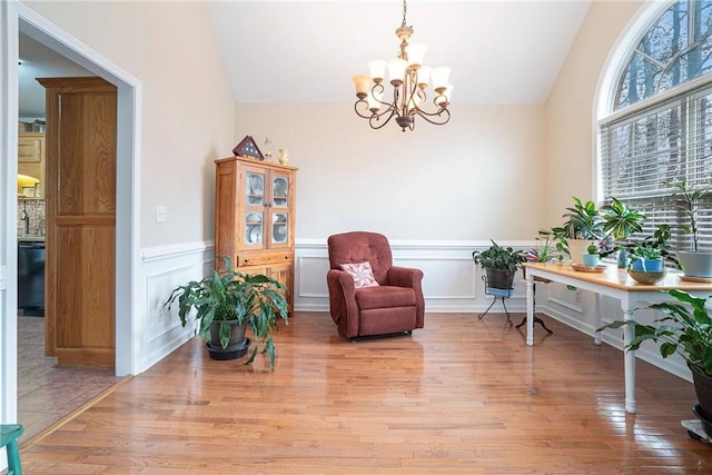 sitting room featuring an inviting chandelier, vaulted ceiling, and light hardwood / wood-style floors