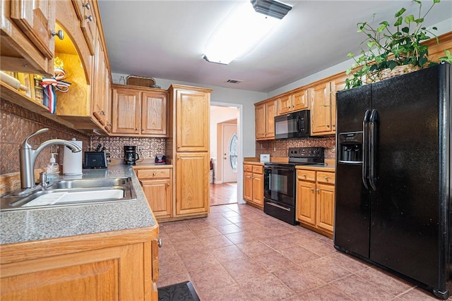 kitchen featuring tasteful backsplash, sink, black appliances, and light tile patterned flooring