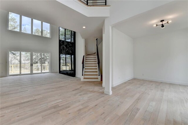 unfurnished dining area with a notable chandelier and light hardwood / wood-style floors