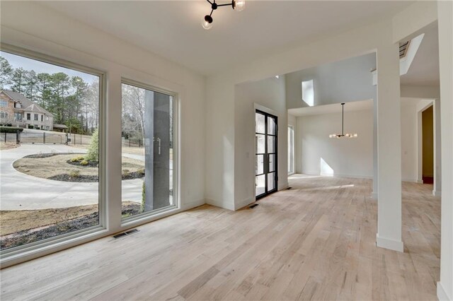 unfurnished living room with a fireplace, a high ceiling, and light wood-type flooring