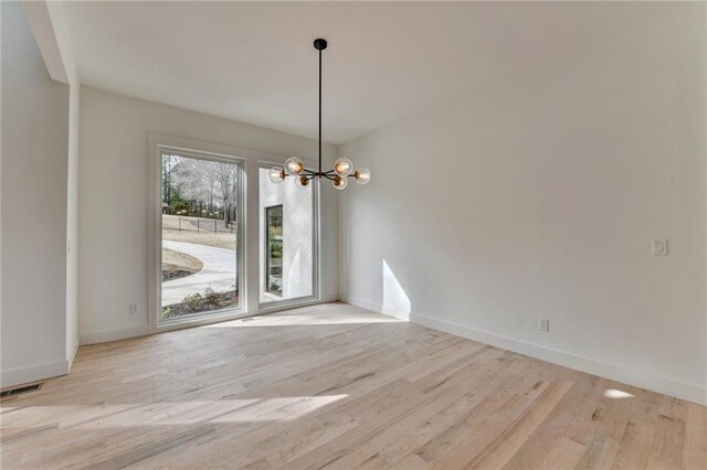 unfurnished living room with a towering ceiling, a fireplace, and light wood-type flooring