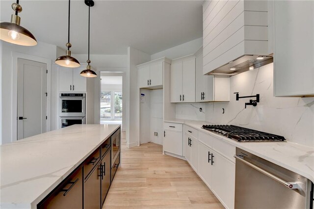 kitchen with a kitchen island, pendant lighting, sink, white cabinets, and stainless steel appliances