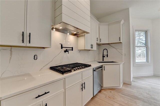 kitchen with white cabinetry, decorative light fixtures, stainless steel appliances, light stone countertops, and backsplash