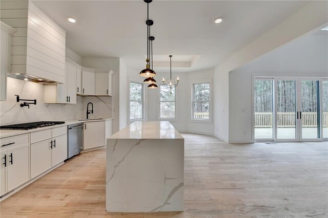 kitchen featuring sink, white cabinets, custom exhaust hood, stainless steel appliances, and light hardwood / wood-style flooring