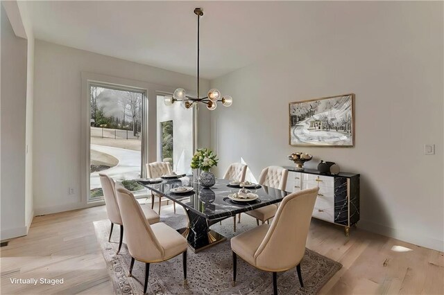 entrance foyer featuring an inviting chandelier, a towering ceiling, and light hardwood / wood-style floors