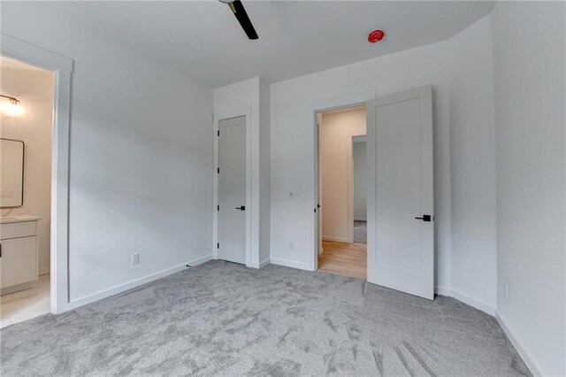 spare room with light carpet and ceiling fan