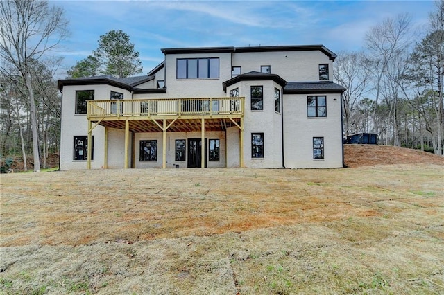 back of property featuring a wooden deck and a yard