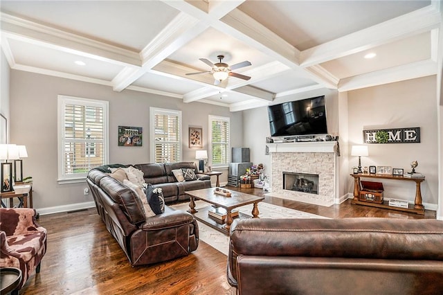 living room with dark hardwood / wood-style flooring, beam ceiling, coffered ceiling, a stone fireplace, and ceiling fan