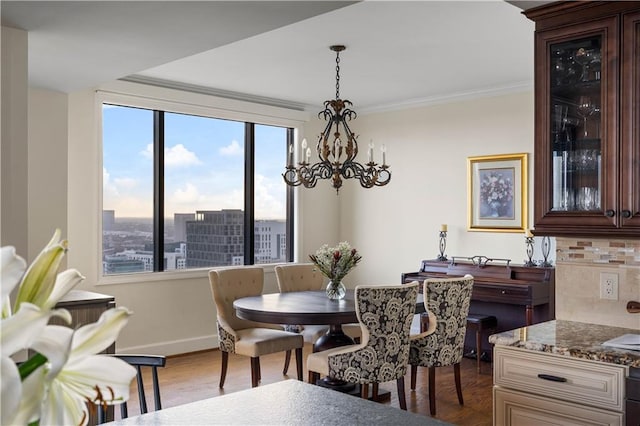 dining space featuring a chandelier, dark hardwood / wood-style flooring, and ornamental molding