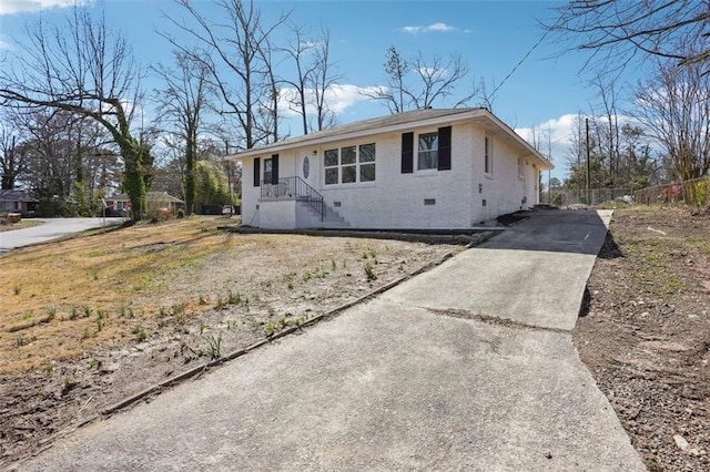 ranch-style house with crawl space, driveway, fence, and brick siding