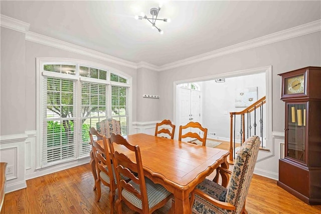 1335 Joy Ct, Suwanee, GA 30024 - dining room with crown molding, light wood-type flooring, a chandelier, stairs, and wainscoting