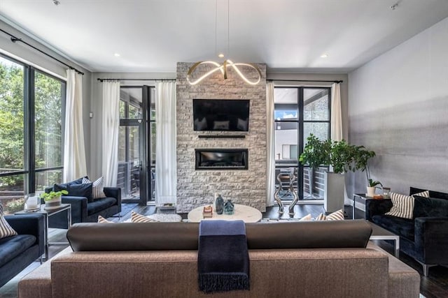 living room featuring a chandelier, wood-type flooring, and a fireplace