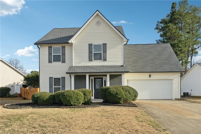 front of property with a garage, a front yard, and central AC