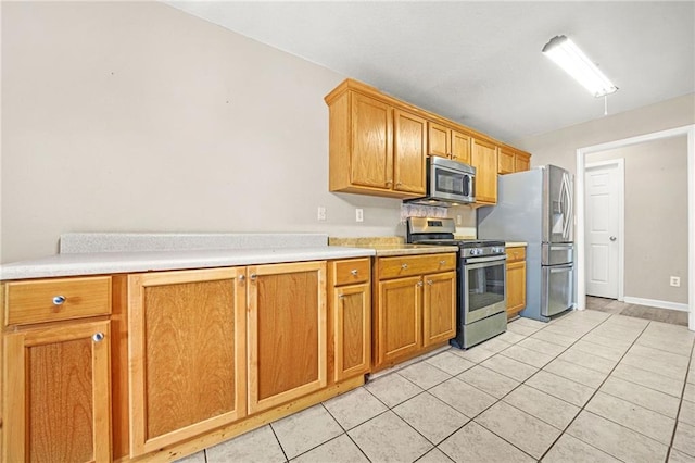 kitchen with light tile patterned floors and stainless steel appliances