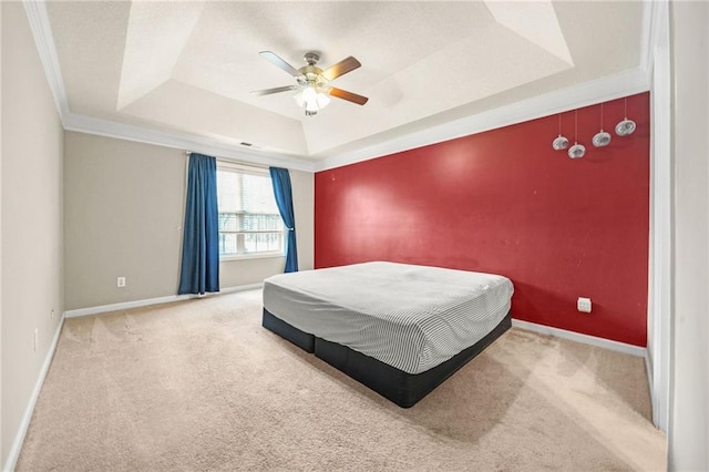 bedroom with a raised ceiling, ceiling fan, carpet, and ornamental molding