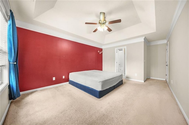 unfurnished bedroom with ceiling fan, crown molding, light carpet, and a tray ceiling