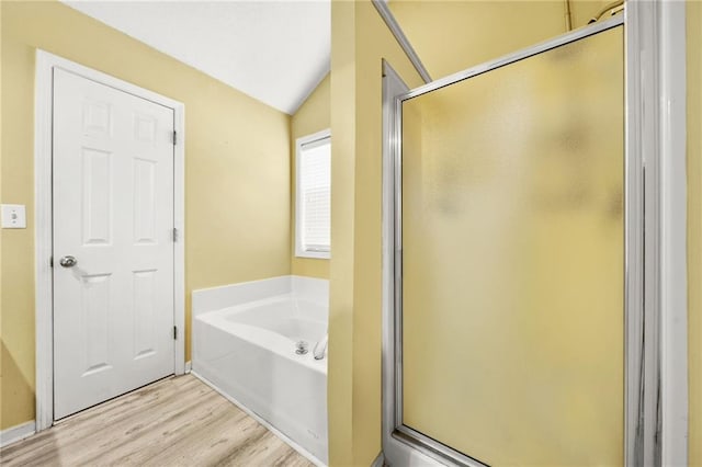 bathroom featuring wood-type flooring, separate shower and tub, and vaulted ceiling