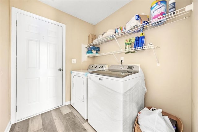 laundry area featuring washer and dryer and hardwood / wood-style flooring