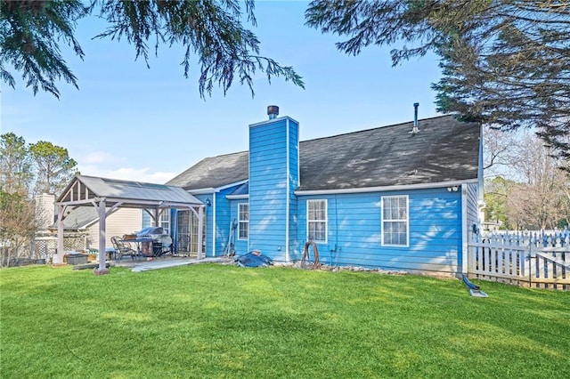 rear view of house with a gazebo, a yard, and a patio area